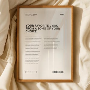 May include: A framed print with a wooden frame. The print features the text "YOUR FAVORITE LYRIC FROM A SONG OF YOUR CHOICE." and other text. The print also has a sound wave graphic and the year 2025.