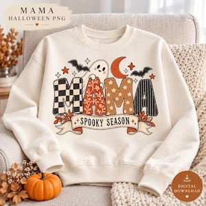Puede incluir: Una sudadera de color crema con un gráfico que incluye el texto MAMA y SPOOKY SEASON. El diseño presenta un fantasma, murciélagos, una luna creciente y estrellas. Las letras están rellenas con varios patrones, incluyendo cuadros y flores.