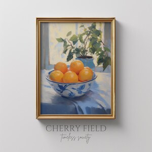 May include: A painting of a bowl of oranges on a blue and white patterned bowl, sitting on a white tablecloth. The oranges are in a bowl on a table in front of a window with a green plant in a pot.