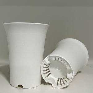 May include: Two white plastic plant pots. One pot is a standard round shape with drainage holes. The other pot is a taller, more flared shape.