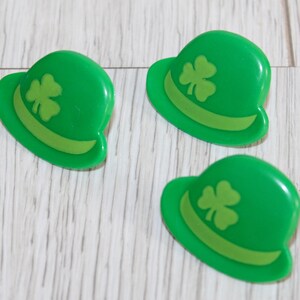 May include: Three green felt shamrock hats with a green shamrock design on the front.