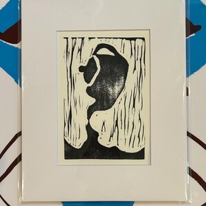 May include: A black and white linocut print of an abstract shape with a textured background.