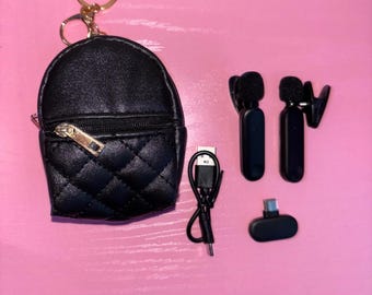 May include: A black quilted faux leather backpack keychain with a gold key ring. The keychain comes with a pair of black wireless earbuds, a charging cable, and a charging adapter.