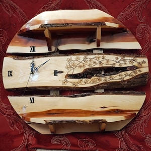 May include: A wooden clock with Roman numerals and a floral design. The clock is made from a tree trunk and has a rustic look. It has two shelves on the sides.