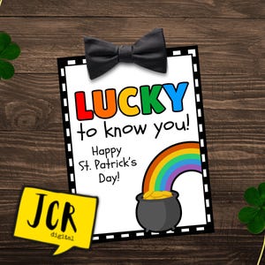 Könnte beinhalten: Eine weiße Karte mit schwarzem Rand und einer schwarzen Fliege oben. Die Karte sagt "LUCKY to know you! Happy St. Patrick's Day!" mit einer Illustration eines Regenbogens und eines Topfes voller Gold.