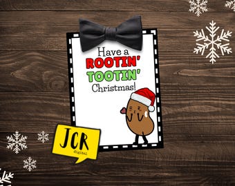 Könnte beinhalten: Eine weiße Karte mit schwarzen und weißen gestrichelten Linien um den Rand. Die Karte hat oben eine schwarze Fliege und sagt "Have a ROOTIN' TOOTIN' Christmas!" mit einer Cartoon-Kartoffel, die einen Weihnachtsmann-Hut trägt und ein Herz hält.