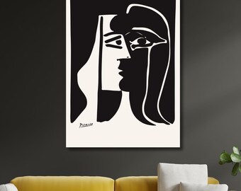 May include: Black and white line art print of a woman's face by Pablo Picasso. The print features a stylized portrait with bold lines and a signature at the bottom.