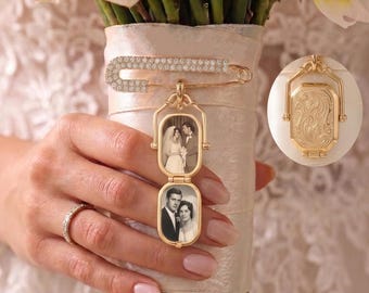 May include: A gold-toned metal safety pin brooch featuring a double-frame locket pendant. The locket displays two black and white photographs of couples. The reverse side of the locket has an ornate, engraved floral pattern. The pin is encrusted with small clear crystals.