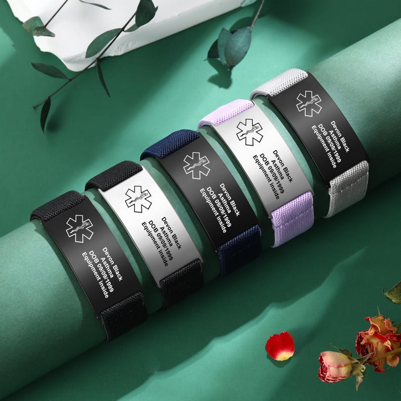 May include: Medical alert bracelets in black, white, navy, lavender, and gray. Each bracelet features a metal plate with a medical symbol and the text "Devon Black, Asthma, DOB 09/09/1999, Equipment Inside."