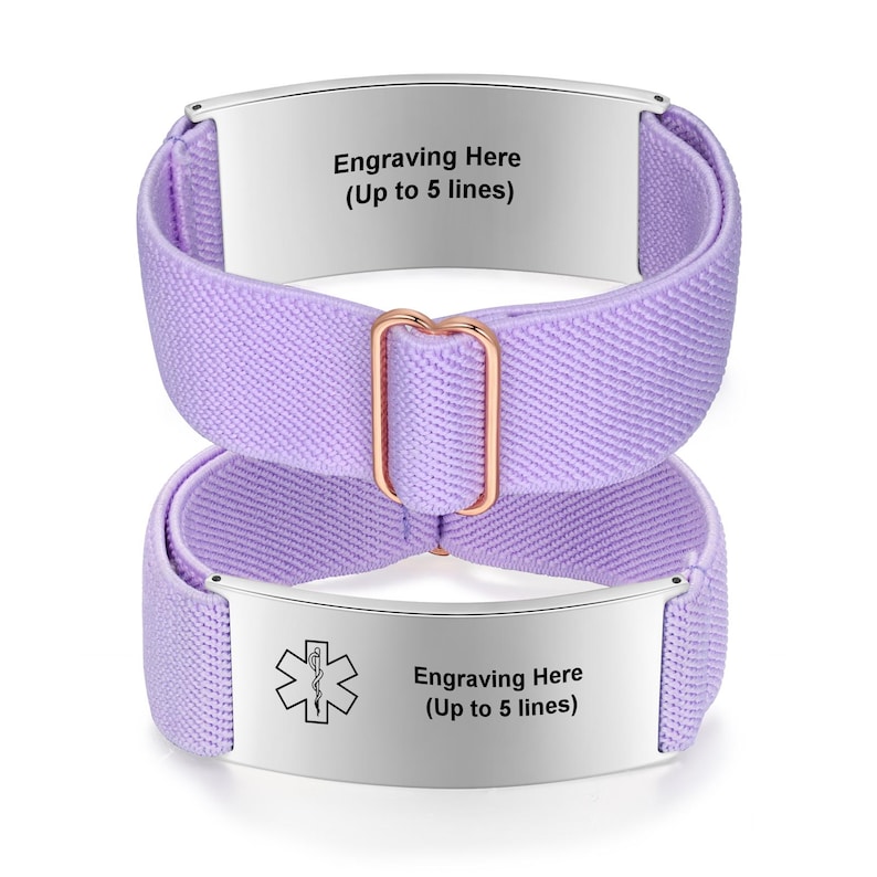 May include: Two lavender medical alert bracelets. Each bracelet has a silver plate with the text "Engraving Here (Up to 5 lines)". One bracelet has a medical symbol. The bands are made of a woven elastic material and are connected by a rose gold-colored buckle.