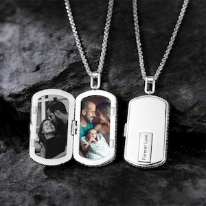 Könnte beinhalten: Silberfarbene Locket-Halskette mit rechteckigem Anhänger. Das Locket öffnet sich und zeigt zwei Familienfotos. Der geschlossene Anhänger trägt die Gravur "Forever Love". Die Kette hat ein Gliederketten-Design.