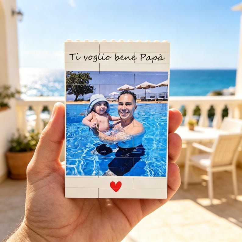 Puede incluir: Foto rectangular impresa en ladrillos Lego blancos. La foto muestra a un hombre sosteniendo a un beb&eacute; en una piscina. El texto "Ti voglio bene Pap&agrave;" est&aacute; encima de la foto, y un coraz&oacute;n rojo est&aacute; en la parte inferior.