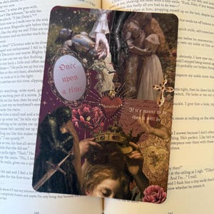 May include: A rectangular bookmark featuring a dark, romantic collage of medieval-inspired imagery, including a knight, a crown, a sacred heart, and a mirror with the text Once upon a time. The design includes the phrase If it's meant to be then it will be.
