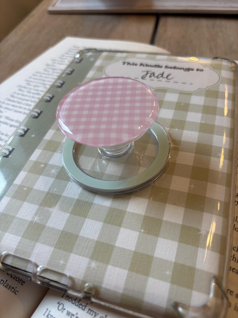 May include: A clear phone case with a light green and white gingham pattern. A pink and white gingham PopSocket is attached.