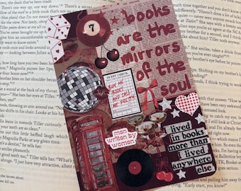 May include: A decorative bookmark with the text "books are the mirrors of the soul." The bookmark features a red telephone booth, a vinyl record, a disco ball, and cherries. The words "man written by women" are also visible.