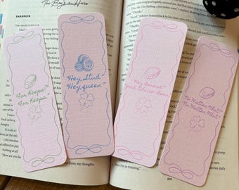 May include: Four pink paper bookmarks with decorative edges and text. The bookmarks have a football and clover design. Text includes "For Keeps", "Hey, Stud, Hey, queen", "Hey Gerard, Yeah Claire Bear", and "No Matter What".