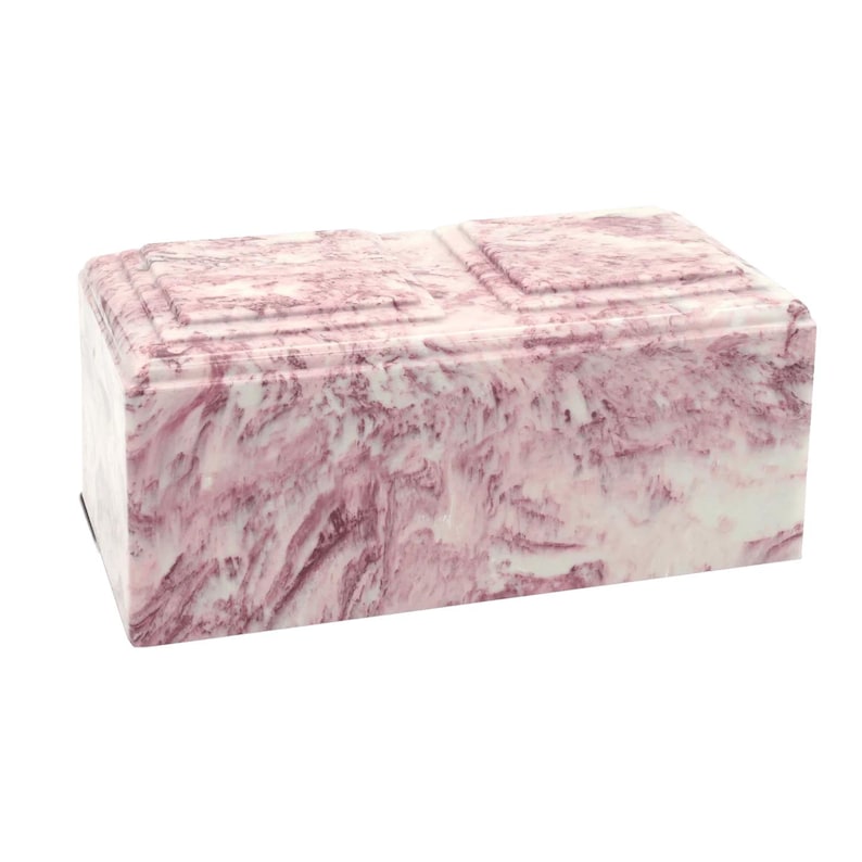 May include: A pink and white marble cremation urn with a rectangular shape.