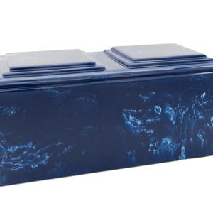 May include: A blue cremation urn with a marbled design. The urn has two separate compartments for ashes.