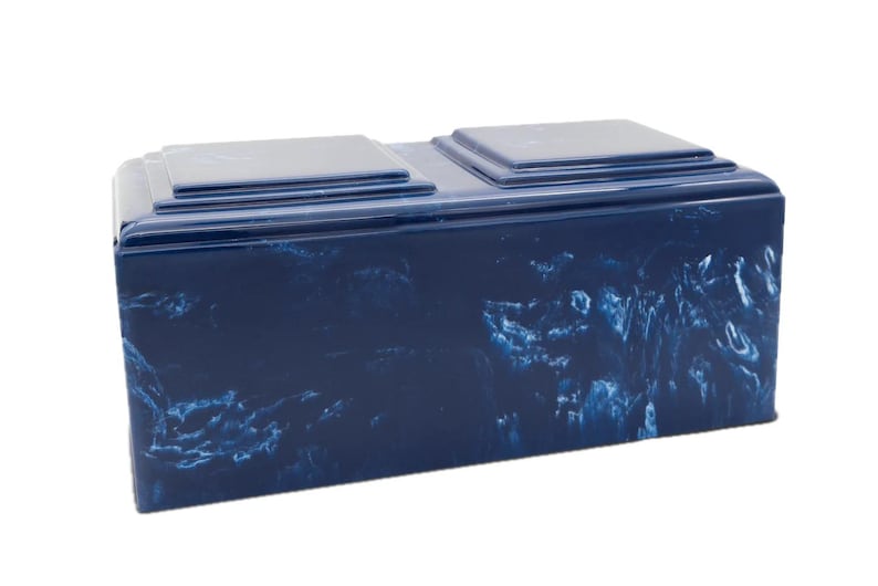 May include: A blue cremation urn with a marbled design. The urn has two separate compartments for ashes.