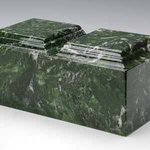 May include: A double-tiered green marble cremation urn with a polished finish. The urn has a rectangular shape with a slightly raised lid.