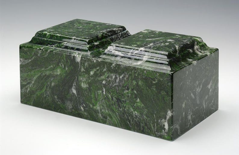 May include: A double-tiered green marble cremation urn with a polished finish. The urn has a rectangular shape with a slightly raised lid.