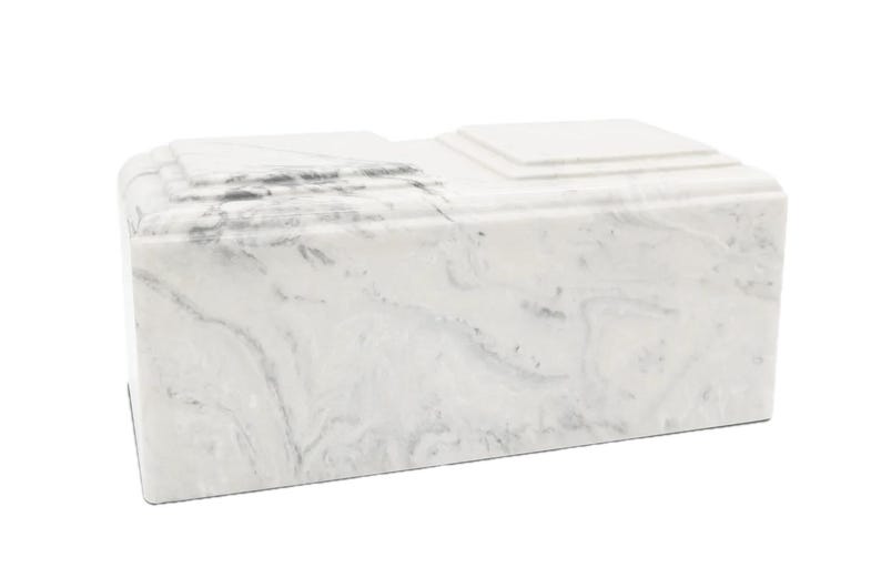 May include: White marble cremation urn with a rectangular shape and a smooth, polished finish.