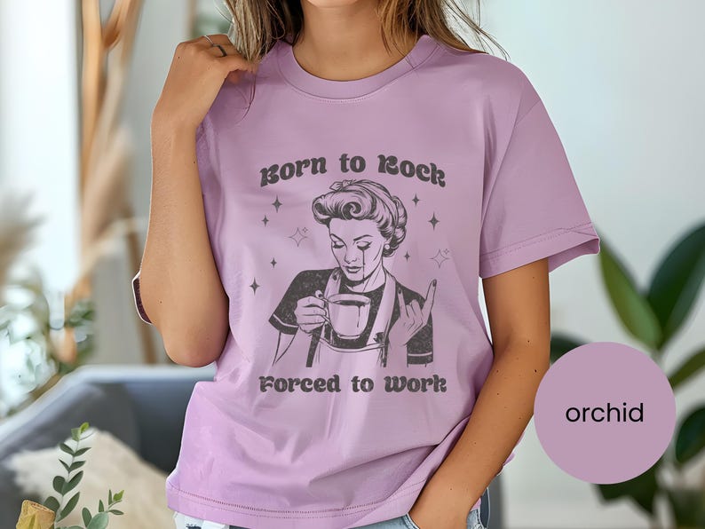 May include: A purple t-shirt with a graphic of a woman holding a cup of coffee and the text "Born to Rock Forced to Work".