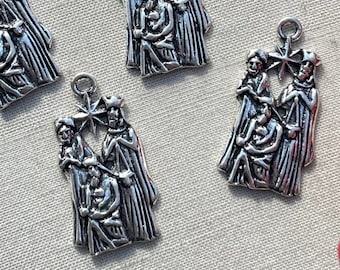May include: Six silver-toned metal charms depicting the three wise men visiting baby Jesus. Each charm features a star above the three figures.