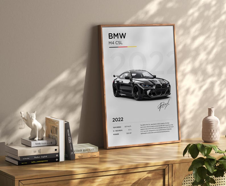 May include: A black and white poster featuring a black BMW M4 CSL with the text "BMW M4 CSL 2022" and technical specifications. The poster has a wood frame.