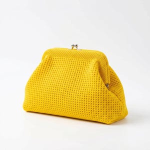 May include: A bright yellow clutch with a textured, perforated design. The bag has a classic frame closure with a silver clasp. The clutch is a vibrant accessory, perfect for carrying essentials.