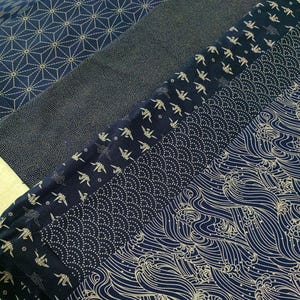 May include: Five different fabric swatches with a dark blue background and a gold pattern. The patterns include geometric shapes, origami cranes, dots, and waves.