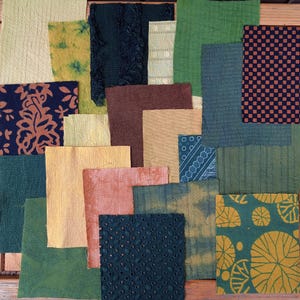 May include: Assortment of fabric squares in various shades of green, brown, and yellow. The fabric squares have different patterns and textures, including plaid, floral, and geometric designs.