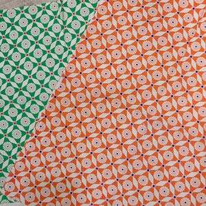 May include: Two fabric swatches with repeating geometric patterns. One swatch is green with white circles and red dots. The other swatch is orange with white circles and blue dots.