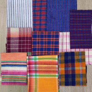 May include: Assortment of fabric swatches in various plaid patterns, including red, blue, orange, and white.