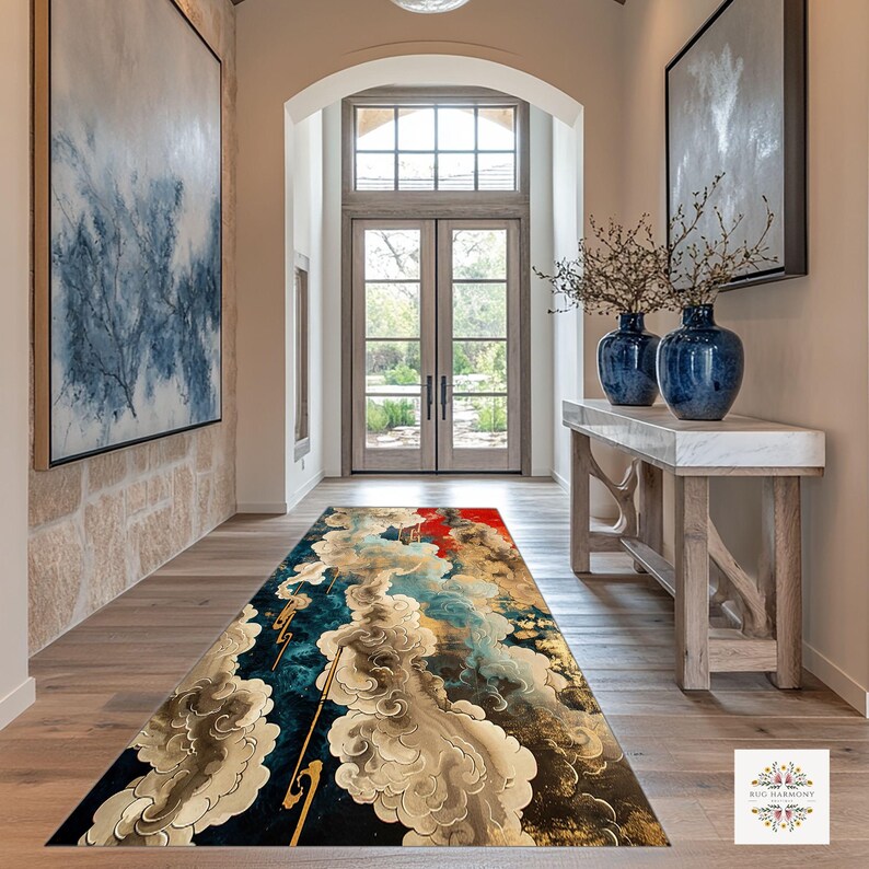 May include: A rectangular rug with an abstract design in a hallway. The rug features a dark blue background with gold, red, and cream-coloured cloud-like shapes. The hallway has light wood flooring and beige walls.