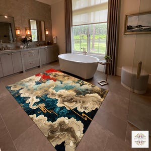 May include: A rectangular rug with a cloud design in a bathroom. The rug features blue, red, gold, and white colours. The bathroom has a white bathtub, grey cabinets, and a large window overlooking a green landscape.