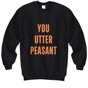 May include: Black sweatshirt with the words "YOU UTTER PEASANT" printed in orange. The sweatshirt has a crew neck and long sleeves. The text is centered on the front of the garment.