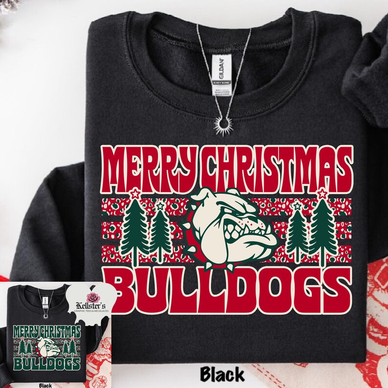 May include: Black sweatshirt with the text "MERRY CHRISTMAS BULLDOGS" in red and white. The design includes a bulldog graphic, Christmas trees, and a festive pattern. The sweatshirt is a Gildan brand.
