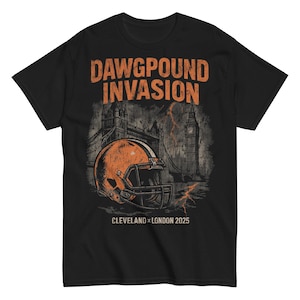 Puede incluir: Camiseta negra con un gráfico de casco de fútbol americano naranja y blanco. La camiseta presenta el texto "DAWGPOUND INVASION" sobre un gráfico del Tower Bridge y el Big Ben. El texto "CLEVELAND x LONDON 2025" está debajo.