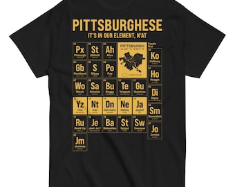 Peut inclure: T-shirt noir avec un motif doré de style tableau périodique. Le motif comporte le mot "PITTSBURGHESE" et la phrase "IT'S IN OUR ELEMENT, N'AT" en haut. Le t-shirt comprend une carte de Pittsburgh.