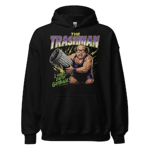 May include: Black hooded sweatshirt featuring a graphic of a man holding a trash can, with the text "THE TRASHMAN" in purple and yellow. Below the image, the text reads "I START EATIN' GARBAGE!"