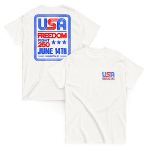 Op de afbeelding: Twee witte t-shirts. Eén shirt heeft een grote blauwe en rode afbeelding met de tekst "USA FREEDOM FIGHT 250 JUNE 14TH WASHINGTON, DC". Het andere shirt heeft een kleinere "USA FREEDOM 250" afbeelding op de borst.