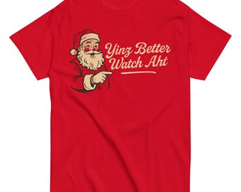May include: Red t-shirt featuring a cartoon Santa Claus pointing to the right. The text "Yinz Better Watch Aht" is printed in a stylized font above a horizontal line. The Santa illustration is in a vintage style.
