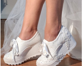 May include: White lace wedding sneakers with a white satin ribbon and a white platform sole.