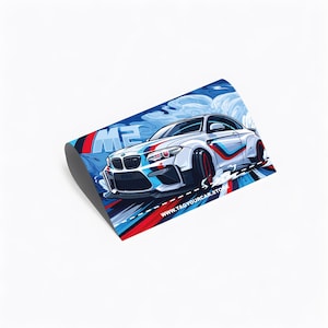 May include: An illustration of a white sports car with blue, red, and black detailing. The car features a racing stripe design and the text "M2". The background shows a blue sky with clouds. The website address "www.tagyourcar.store" is also visible.