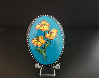 Fleurs jaunes sur rocher peint en turquoise