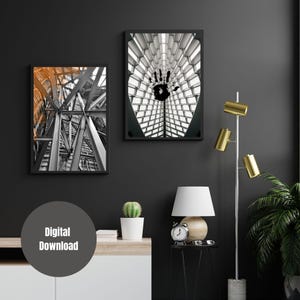 Peut inclure: Deux impressions encadrées noires de structures architecturales. L'impression de gauche montre une image en noir et blanc de l'intérieur d'un bâtiment avec un réseau complexe de poutres et de supports. L'impression de droite montre une image en noir et blanc de l'intérieur d'un bâtiment avec une grande empreinte de main noire au centre.