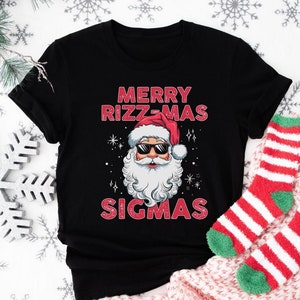 May include: Black t-shirt with a red and white illustration of Santa Claus wearing sunglasses and the text "Merry Rizz-Mas Sigmas".