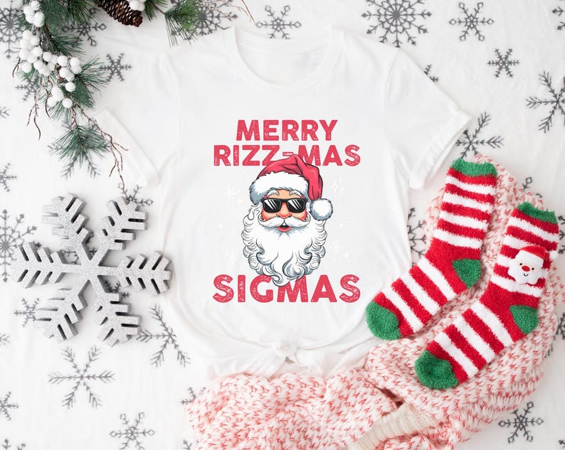 May include: White t-shirt with a red and white Santa Claus graphic and the text "Merry Rizzmas Sigmas".