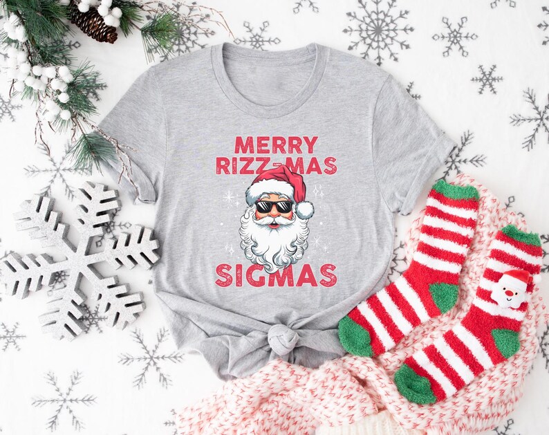 May include: A gray t-shirt with a red and white Santa Claus graphic and the text "Merry Rizzmas Sigmas".